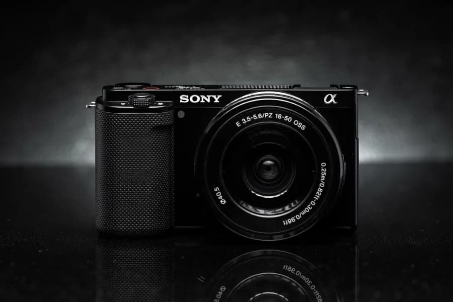 Câmera Sony ZV-E10 de frente, com a lente 16-50 mm